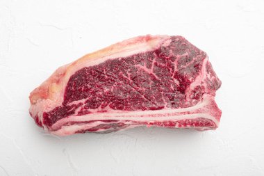 Fresh, huge and appetizing dry aged club steak set, on white stone  background