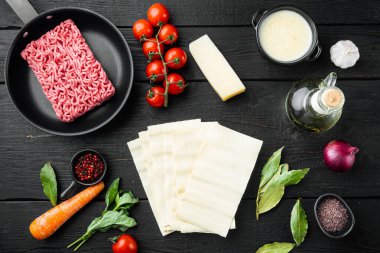 Fresh ingredients for lasagna set, on black wooden table background, top view, flat lay