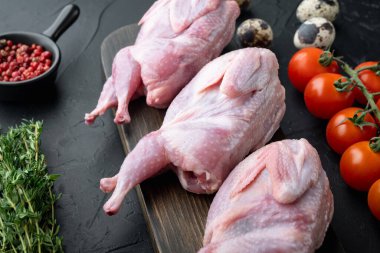 Fresh  raw meat quail ready for cooking, on black textured background