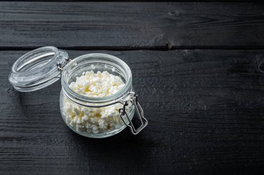 Süzme peynir, kaymak, siyah ahşap masa üzerinde metin için yer var.