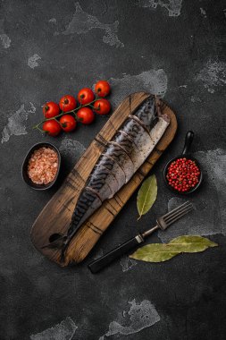 Terbiye edilmiş uskumru seti, siyah taş masa arkaplanı üzerinde, üst görünüm düz yatıyordu