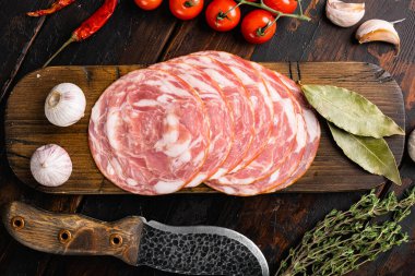 Tütsülenmiş sosis seti, eski koyu ahşap masa zemininde, üst manzara düz yatıyordu.