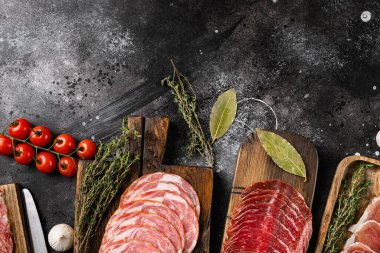 Farklı et aperatifleri coppa, prosciutto seti, siyah taş masa arkaplanı, üst görünüm düz, metin alanı için kopyalama alanı