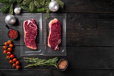 Noel ve Yeni Yıl setine sığır eti rulosu, siyah ahşap masa arkaplanı, üst görünüm düz, metin alanı için fotokopi alanı