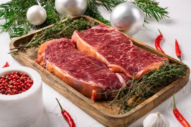 Biftek seti, beyaz taş masa arkasında.