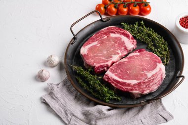 Et setinden çiğ biftek, beyaz taş masa zemininde, metin için kopya alanı ile.
