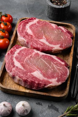 Baharatlı taze pirzola bifteği, gri masa arkasında.