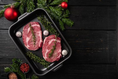 Taze çiğ biftek seti, siyah ahşap masa arkaplanı, üst görünüm düz, metin için kopyalama alanı ile