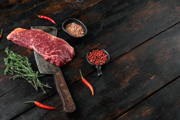 Raw fresh New York beef steak set, on old dark  wooden table background, with copy space for text