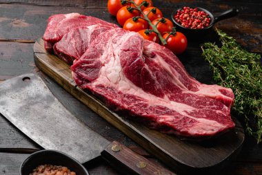 Siyah Angus çiğ biftek Chuck göz devirme seti, eski siyah ahşap masa arka planı