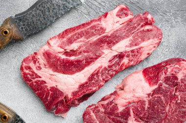 Siyah Angus çiğ biftek Chuck göz devirme seti, gri taş masa arka planı, üst görünüm düz yatıyordu