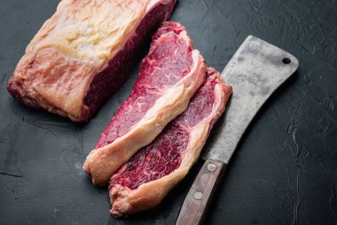 Striptiz bifteği, siyah arka planda çiğ et.