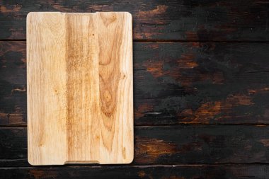 Tahta kesme seti, eski koyu ahşap masa arkaplanı, üst görünüm düz yatay, metin veya ürün için kopyalama alanı ile