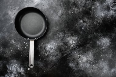 Metin veya yiyecek için kopyalama alanı olan demir kızartma tavası seti, üst görünüm düz, siyah taş masa arkaplanı üzerine