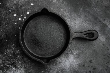 Metin ya da yiyecek için metin ya da yiyecek için kopyalama alanı olan boş kızartma tavası seti, en üstteki düz görünüm, siyah taş masa arkaplanı üzerinde