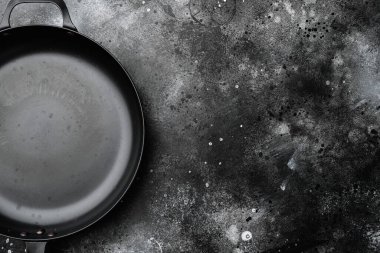 Metin veya yiyecek için kopyalama alanı olan eski boş tava seti, üst görünüm düz, siyah taş masa arkaplanı üzerinde