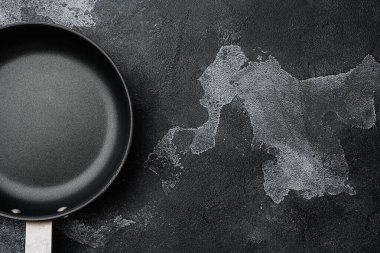 Boş tava, metin ya da yiyecek için kopyalama alanı olan tava ya da yiyecek için metin ya da yiyecek seti, üst görünüm düz, siyah koyu taş masa arkaplanı üzerinde