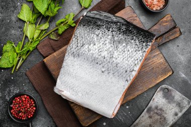 Büyük bir parça çiğ somon balığı seti, siyah taş masa arkaplanı, üst manzara düz