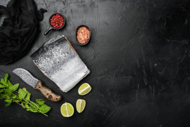 Büyük bir parça çiğ somon balığı seti, siyah taş masa arkaplanı, üst görünüm düz, metin alanı için kopyalama alanı ile