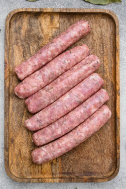 Çiğ sosis malzemeleri seti, gri taş masa arka planında, üst görünüm düz yatıyordu