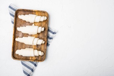 Ham kruvasan hamur seti, beyaz taş masa zemininde, üst görünüm düz yatay, metin alanı için kopyalama alanı