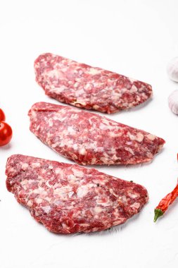 Organik çiğ et, yuvarlak köfteler, beyaz taş masa zemininde.