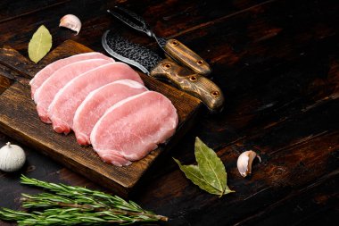 Taze domuz eti seti, eski koyu ahşap masa zemininde, metin için kopyalama alanı var.