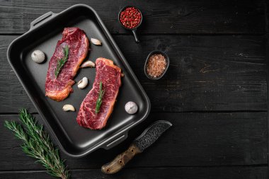 New York biftek seti, siyah ahşap masa arkaplanı, üst görünüm düz, metin için kopyalama alanı ile