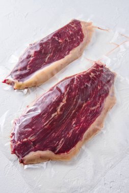 Picanha bifteği vakumu beyaz beton desenli arka planda organik et paketlemişti.