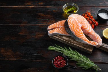 Bitkilerle dolu çiğ somon filetosu. Kopya alanı olan eski ahşap masa üzerinde..