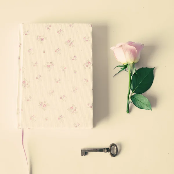 Notitieboekje met roze rozen en sleutel — Stockfoto