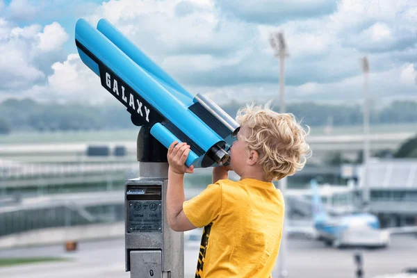 Ein Junge Beobachtet Durch Ein Teleskop Ein Startendes Flugzeug Flughafen lizenzfreie Stockbilder