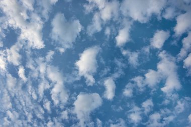 Mavi gökyüzünün arka planında kabarık beyaz bulutlar.