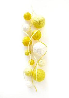 Beyaz arka plan. Beyaz ve sarı iplik, iplik yumakları.