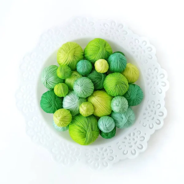 Πράσινες Κλωστές Λευκό Σκαλιστό Πιάτο Λευκό Φόντο Νήματα Για Πλέξιμο — Φωτογραφία Αρχείου