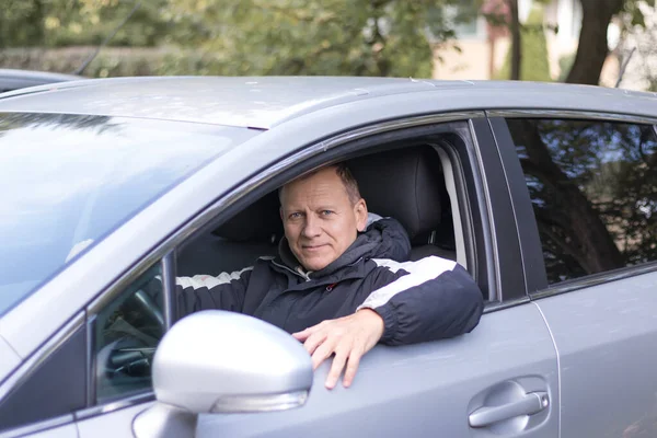 中年の男性55 60歳のドライバーは車に座って笑顔で ストック写真
