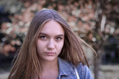 16 yaşında, uzun kahverengi saçlı, kahverengi gözlü, yakın plan portresi olan hoş bir genç kız.