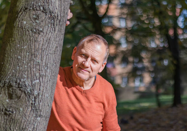 portrait of handsome middle aged man in autumn park