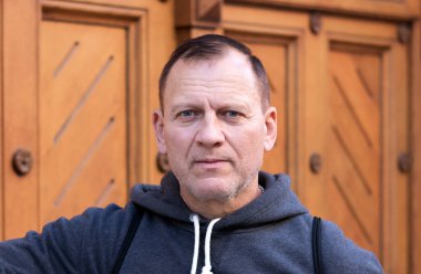 50-60 yaşlarında, yakışıklı, aktif, olgun bir adamın göğüs hizasında portresi.