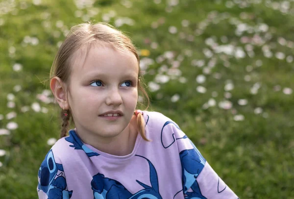 一个7岁的欧洲金发女孩坐在绿油油的草地上的画像 — 图库照片