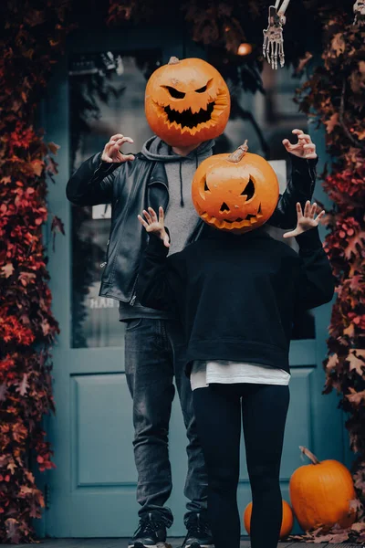 Couple with pumpkin heads scares passers-by at the camera — Stock Photo, Image