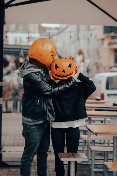 Guy and girl with pumpkin heads look at each other — Stock Photo, Image