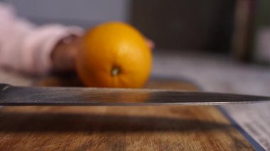 Bayanlar taze turuncu mutfak üzerinde kesme eller