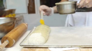 Bir adam satılık elmalı turta hazırlar. Fırçayla kaplanarak