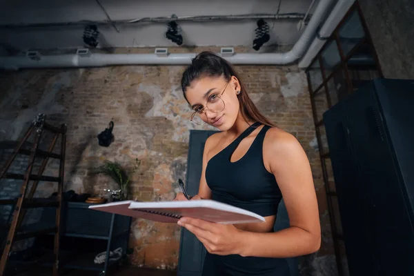 Jovens mulheres de pé escrevendo algo no caderno. — Fotografia de Stock