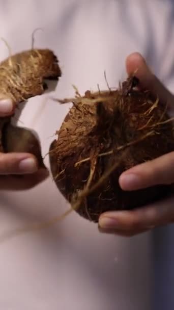 Female hands open the coconut, coconut water pours out — Stock Video