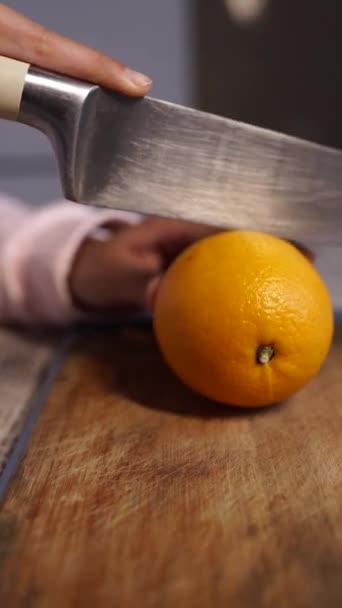 Frauenhände schneiden frische Orangen in Küche — Stockvideo