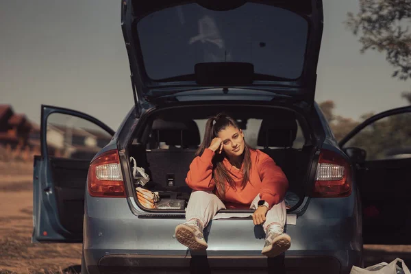Attraente giovane donna che riposa nel bagagliaio di una macchina — Foto Stock