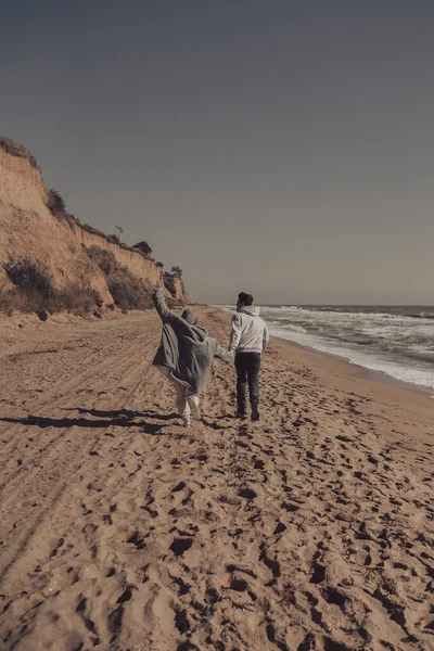 Homem e mulher desfrutam um do outro, correm ao longo da costa — Fotografia de Stock
