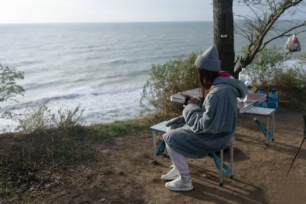 年轻女子在海景的智能手机上拍照 — 图库照片